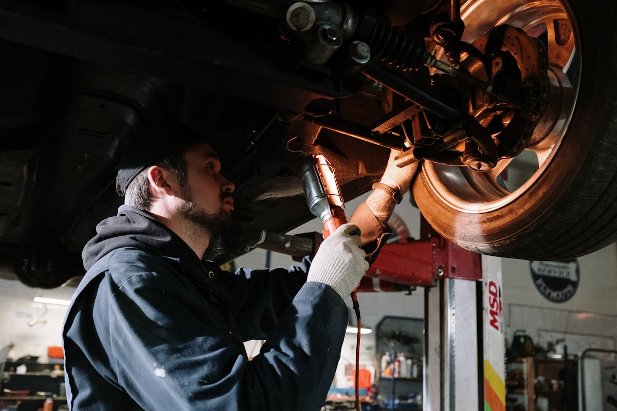Mechaniker prüft Motorraum eines Autos in der Werkstatt